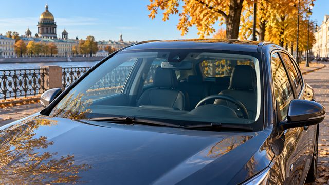 Праворульный автомобиль с хорошо видимым рулём справа за лобовым стеклом на осенней улице Петербурга